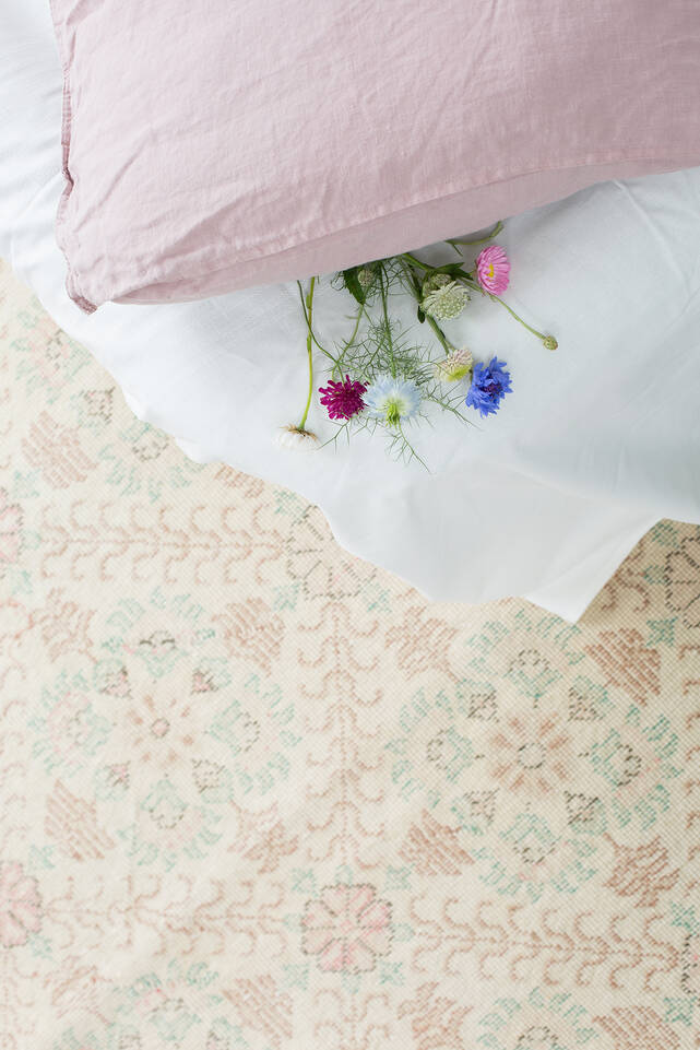 Wit,  colored vintage - turkiet - vloerkleed in een slaapkamer.