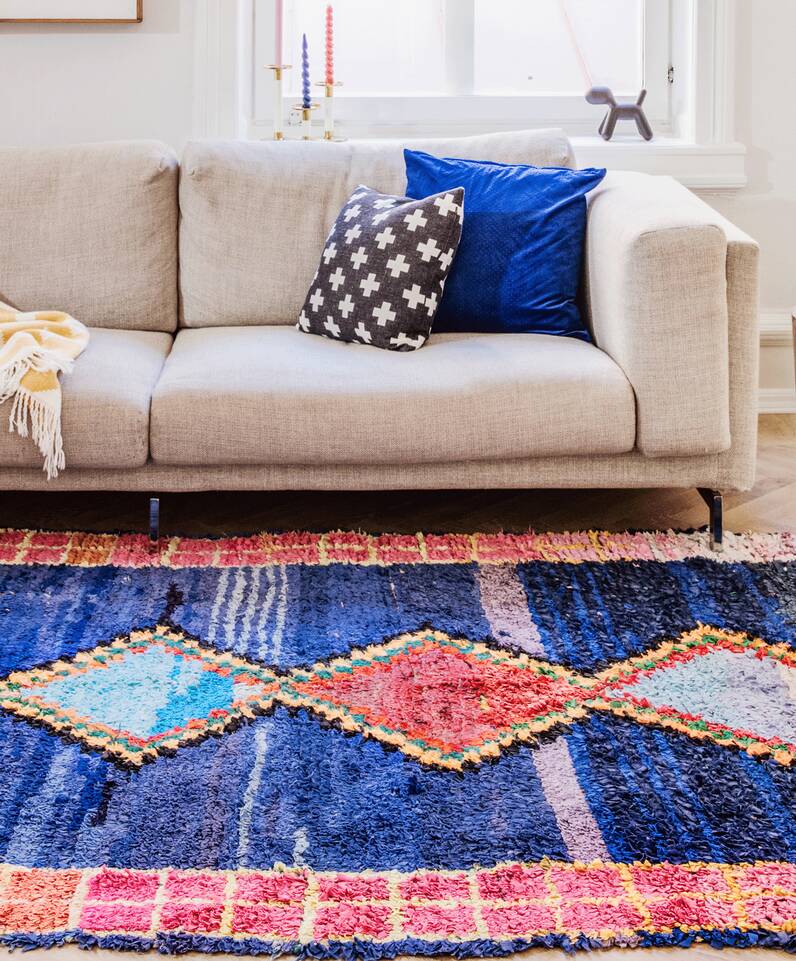 リビングルーム内の青色のてberber moroccan - boucherouite絨毯。