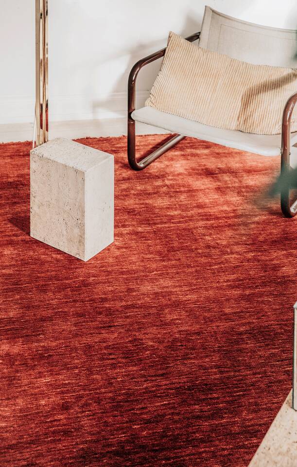 Rødt  handloom fringes - tæppe  i en stue.