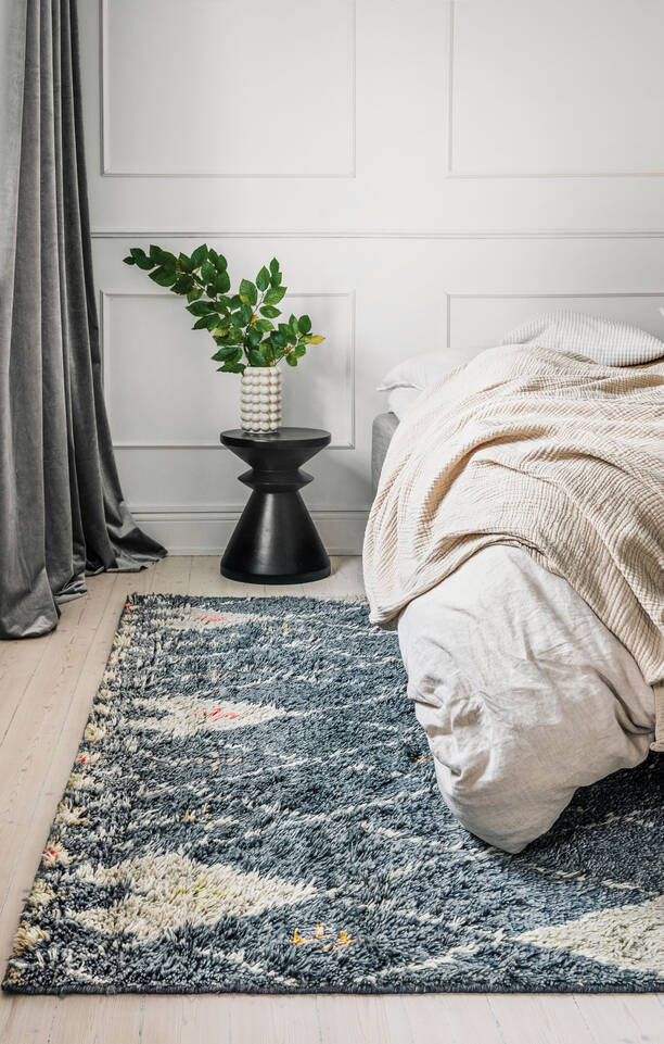 Zwarte / grijs,  berber shaggy - vloerkleed in een slaapkamer.