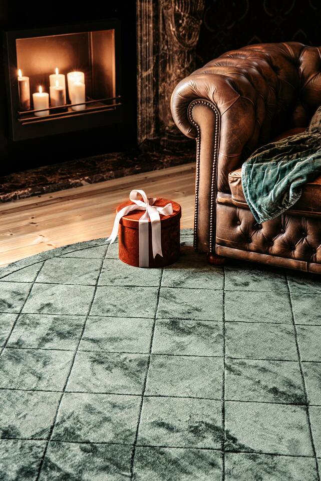 Zöld, kerek viszkóz modern szőnyeg
 egy nappali.