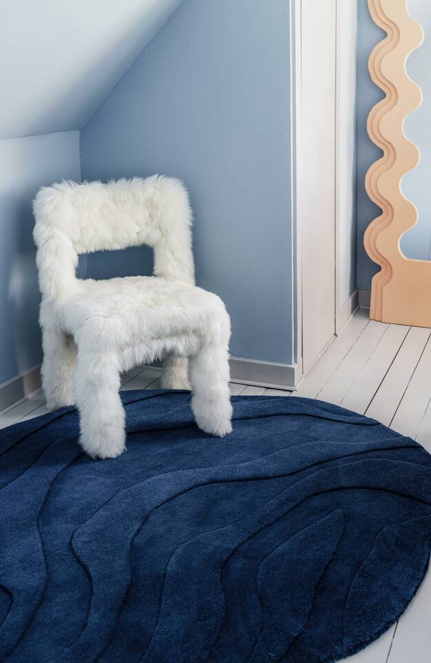 Blåt runde handtufted - tæppe  i en stue.