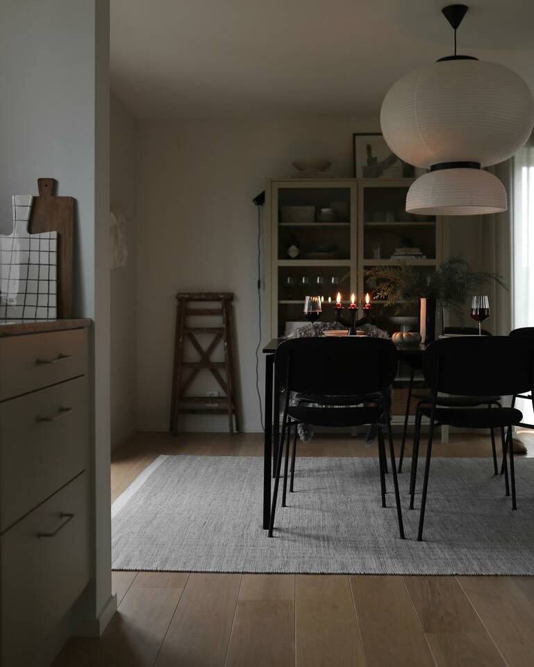 White  röllakan / dhurrie -  Carpet in a dining area.